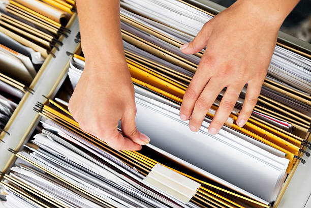 Hands sorting through folders in a file cabinet